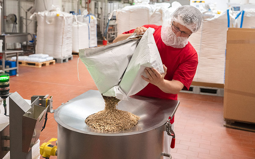 Je nach Sorte des Corny-Riegels kommen die entsprechenden Zutaten aus Säcken in den Mischer.