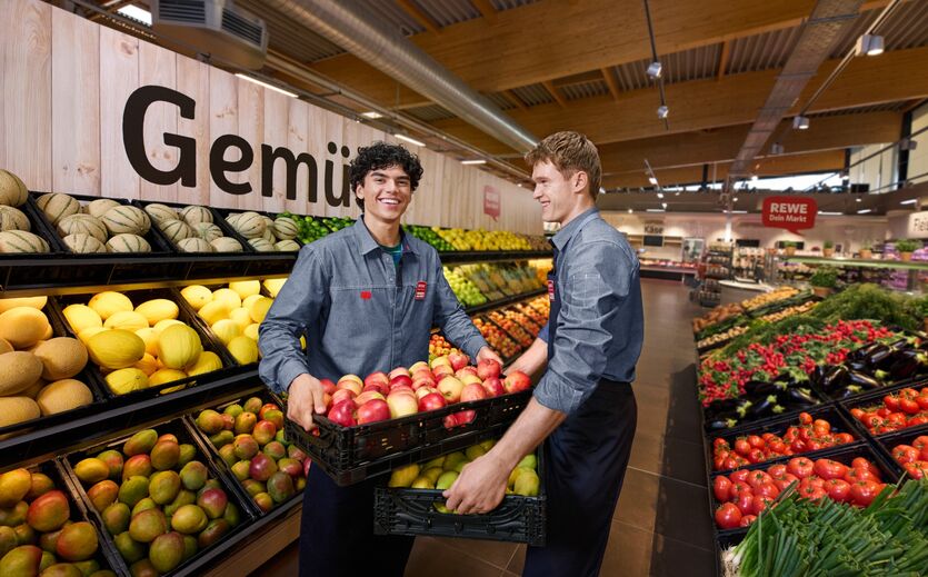 Ausbildungskampagne von Rewe: Zwei junge Männer  verräumen Obst in einem Supermarkt.n