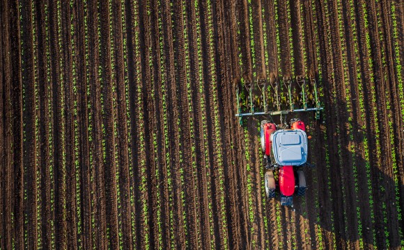Tractor cultivating field at spring,aerial view