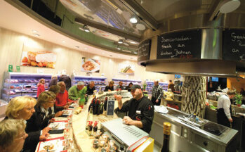 Einkaufserlebnis Frisch zubereitete Speisen können die Kunden an mehreren Stellen im Markt genießen, hier am Grill-Point neben Fleisch- und Fischtheke.