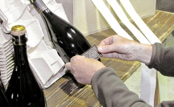 Handarbeit: So arbeitet man heute noch in kleinen Winzerbetrieben: Erst wird die Flasche blank geputzt, dann werden Etiketten manuell aufgeklebt.