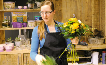 Blumig: Im Eingangsbereich bietet eine Mitarbeiterin von Blume 2000 ihre Ware an.