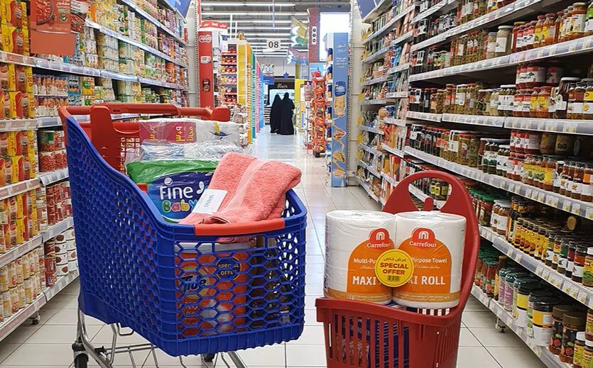 Einkaufswagen und Korb mit Carrefour Produkten.