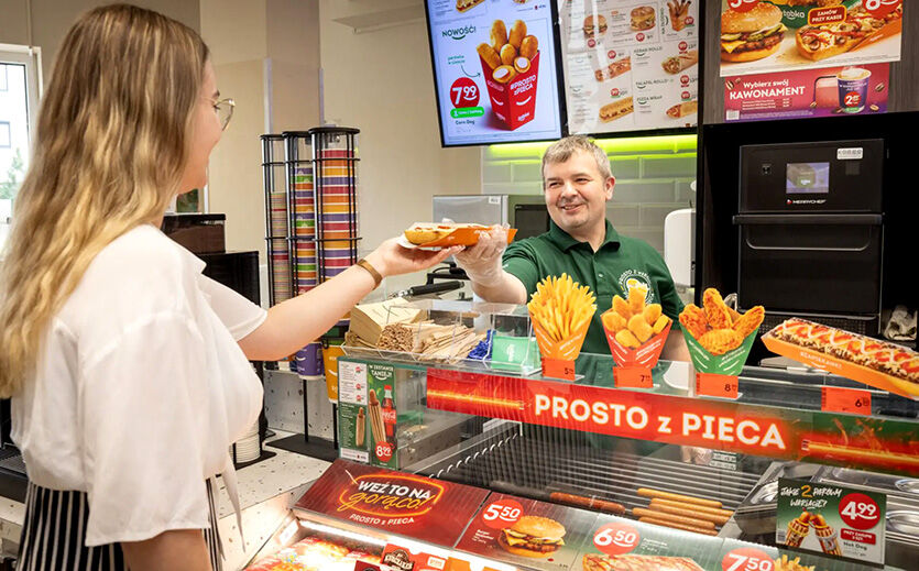 Żabka steigert Umsatz um 15 Prozent: Eine Frau kauft an einer Theke von Zabka ein Fertiggericht.