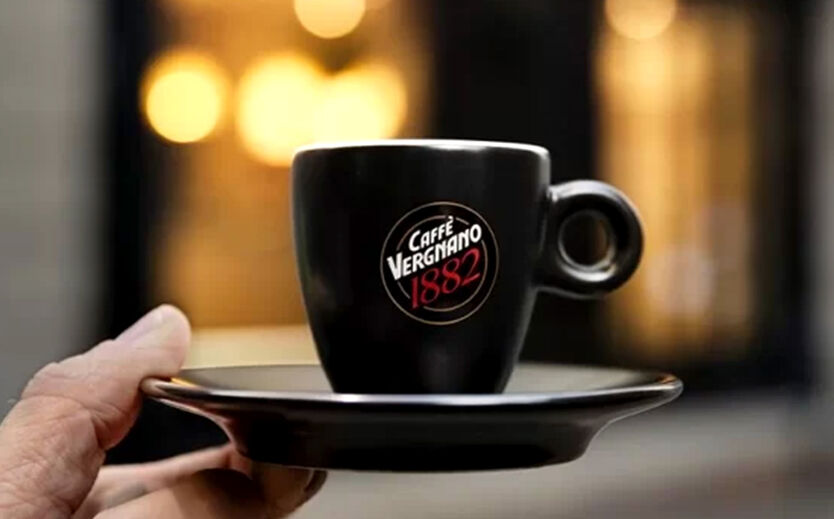 Caffè Vergnano steigert Umsatz auf 125 Millionen Euro: Eine Hand hält eine Tasse mit der Aufschrift Caffè Vergnano hoch.