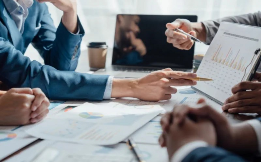 Manager besprechen Finanzunterlagen und Diagramme in einem Meeting.