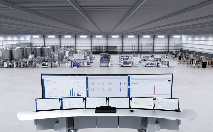 Blick auf eine Produktionshalle mit Steuerpult und Bildschirmen.