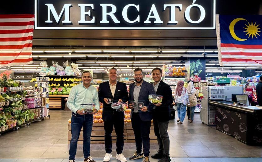 Armin Rehberg und Jaime Sánchez von SanLucar (mitte l. und r.) stehen mit Partnern vor einer Mercató-Filiale in Malaysia.