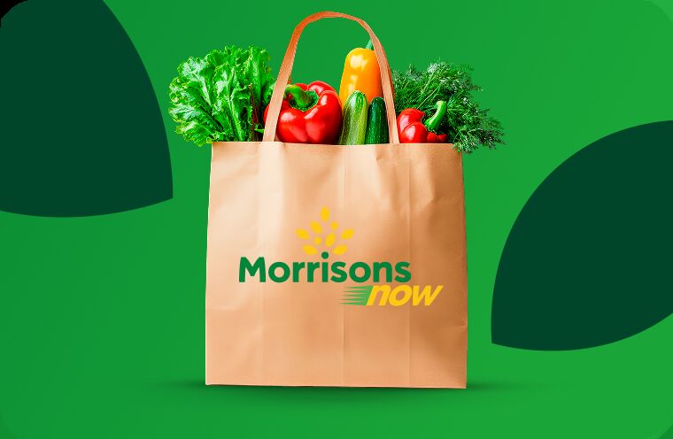 Morrisons startet Ein-Stunden-Lieferservice in Großbritannien: Eine Papiertüte mit der Aufschrift Morrisons now gefüllt mit Obst und Gemüse vor einem grünen Hintergrund.