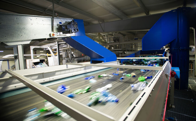 PET to PET steigert Recyclingmenge um 14,5 Prozent: Blick in die Recycling-Anlage mit PET Flaschen auf einem Förderband.