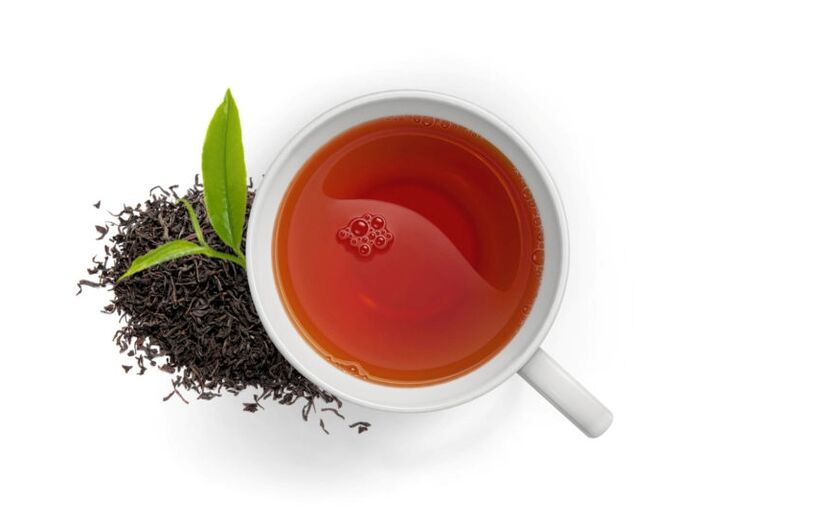 Zahlen zum Teekonsum: Blick von oben auf eine Tasse Tee; daneben Schwarzer Tee.