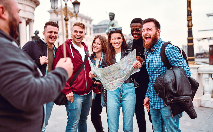 Tourismus kurbelt Handel an: Gruppe von Touristen mit Reiseführer; eine Person hält einen ausgebreiteten Stadtplan in der Hand.