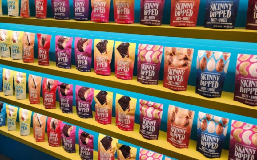 Bunte Snackbeutel stehen in mehreren Reihen im Regal