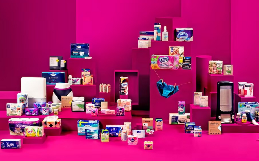 Verschiedene Essity-Produkte wie Tena, Zewa, Tempo und Libresse sind vor pinkem Hintergrund ausgestellt.