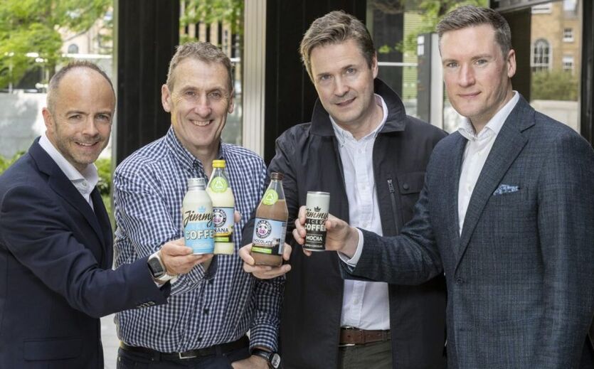 Von links nach rechts: Andrew Bourg, Alan Cunningham, Hilliard Lombard und Warren Codd stehen im Freien und präsentieren Produkte von Jimmy’s Iced Coffee und Münsterland.