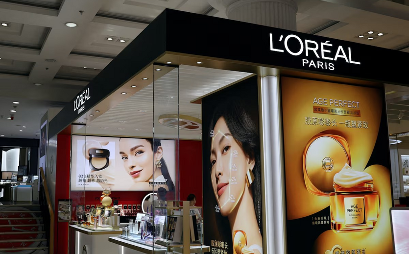 L’Oréal Verkaufsstand mit großen Werbedisplays und Kosmetiktheken in einem Einkaufszentrum in Peking.