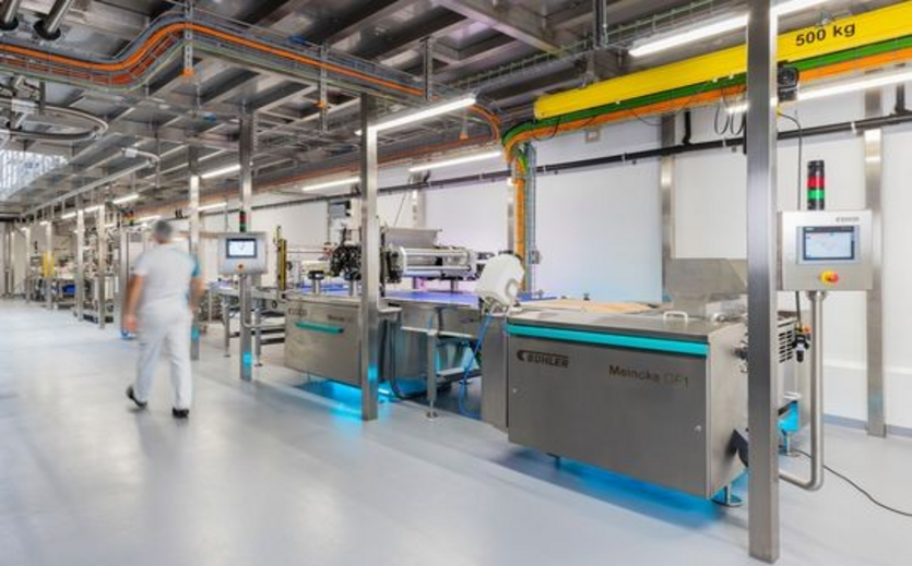 roduktionshalle mit modernen Bühler-Maschinen und einem Mitarbeitenden