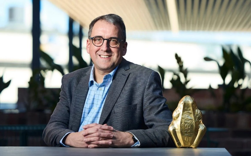 Peter Millard sitzt an einem Tisch