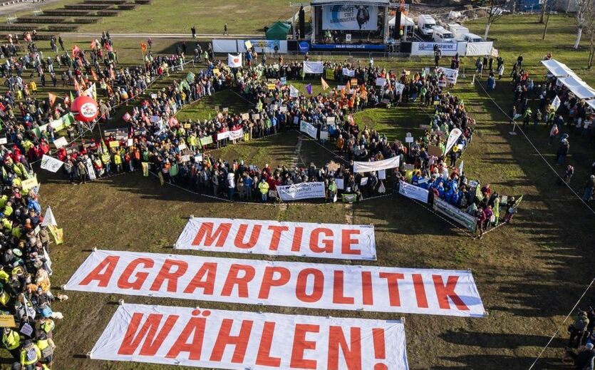 Demonstration gegen Agrarpolitik: Gruppe von Demonstranten von oben fotografiert; auf dem Boden Transparente mit der Aufschrift Mutige Agrarpolitik wählen.ft
