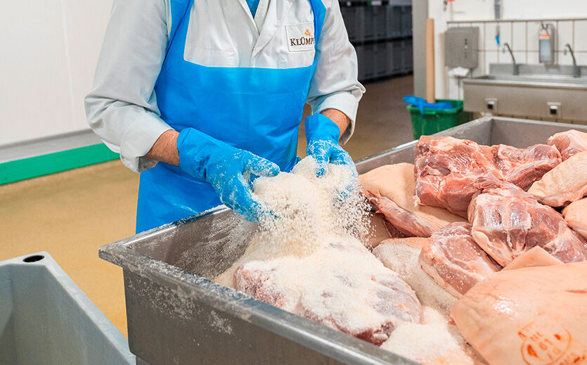 Die Mitarbeiter salzen die Schinken nach einem geheimen Rezept von Hand und schichten sie während der Salzzeit wöchentlich in der Mutterlake um.