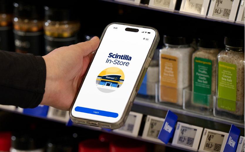 Smartphone mit geöffneter Scintilla In-Store App vor einem Supermarktregal. 