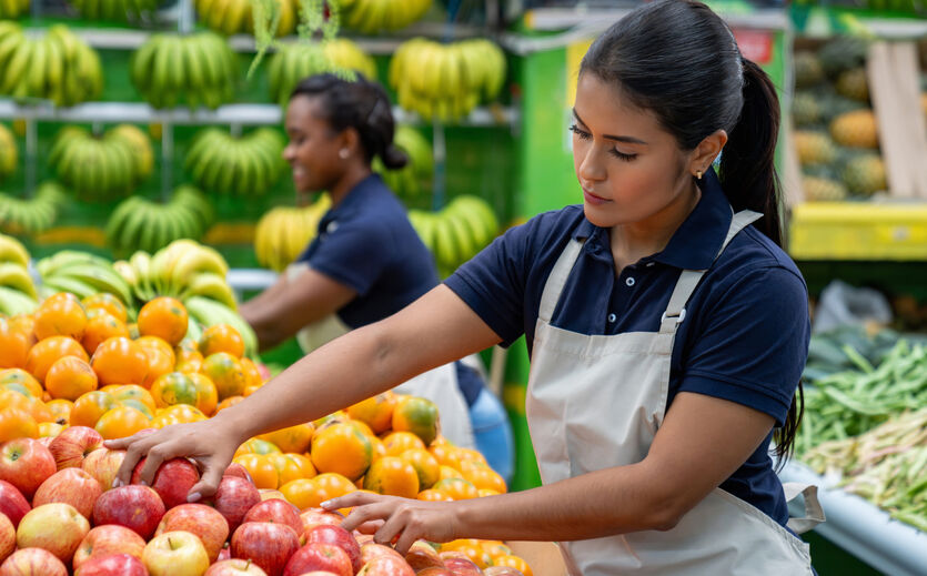 Zahlen zur Dualen Berufsausbildung: Zwei Frauen mit dunklem Teint sortieren Obst in einem Supermarkt.n