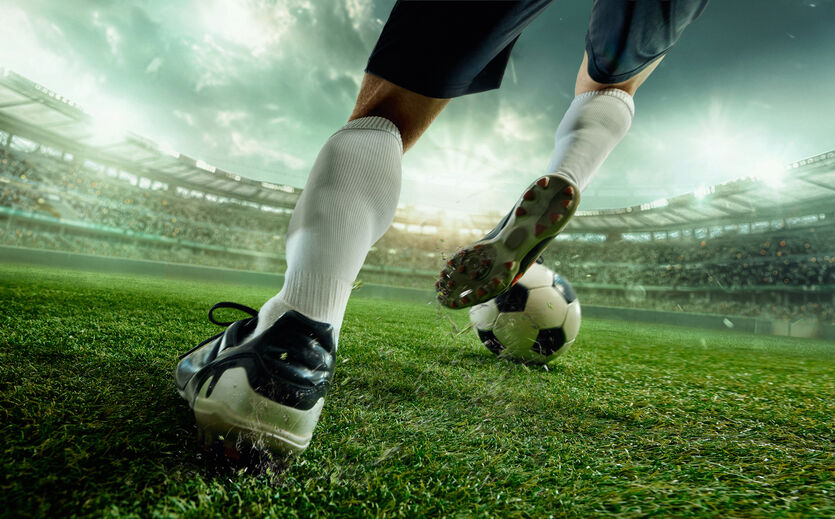 Wolt-Umfrage zur Fußball-WM: Spieler tritt Fußball; im Stadion.