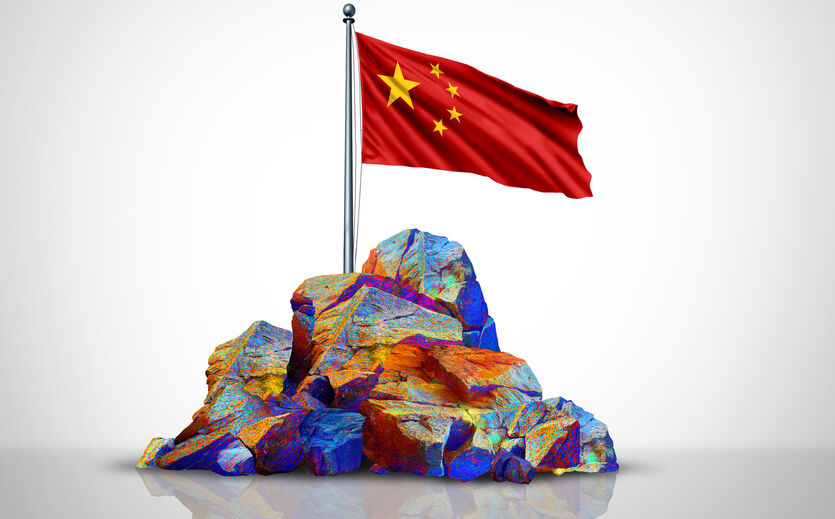 IW-Umfrage zu kritischen Rohstoffen: kleine, glitzernde Steine aufgestapelt, darauf eine Flagge Chinas. et