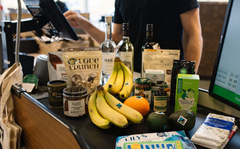 Appell zu Produktionskosten: verschiedene Artikel liegen auf Supermarkt-Band.