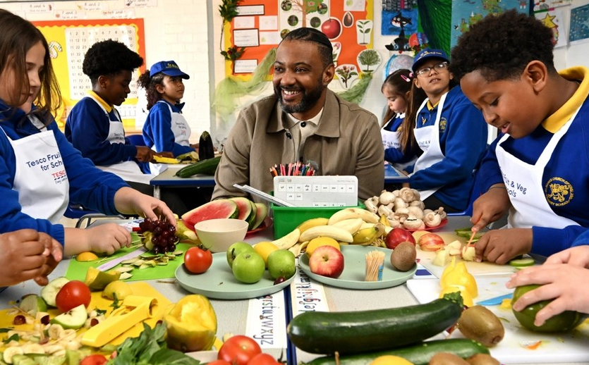 Kinder in einer Schulklasse mit Obst und Gemüse. 