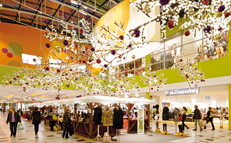 Zwölf Meter lange Lichtzweige über den Menschen vermitteln den Eindruck, in einem Zauberwald zu sein – A 10 Center, Wildau